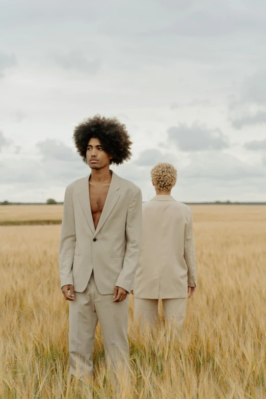 a man and a woman standing in a wheat field, an album cover, by Cosmo Alexander, pexels contest winner, wearing tight suit, afro hair, beautiful male twins portrait, one man is blond