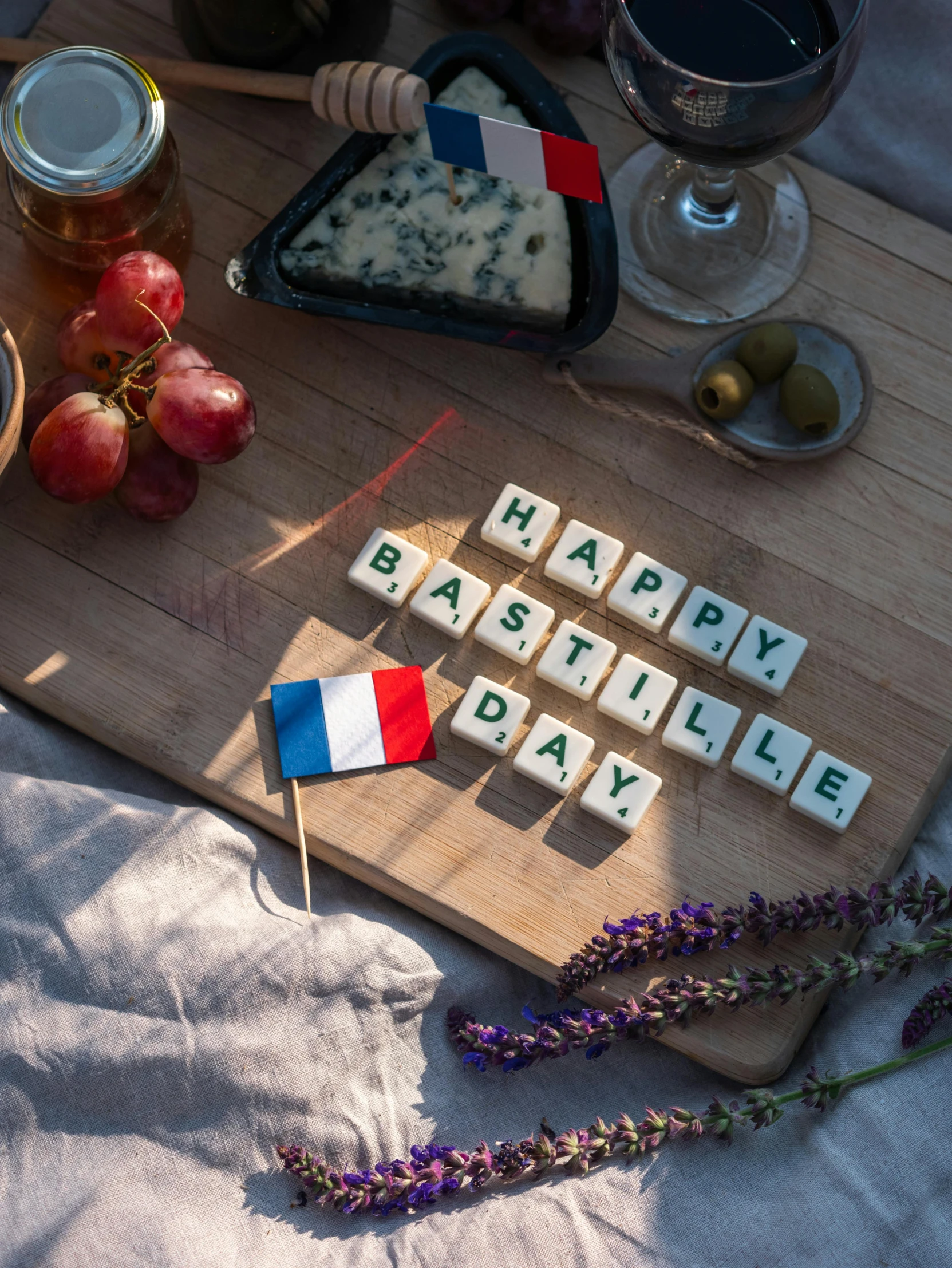 a wooden cutting board sitting on top of a table, a picture, by Julia Pishtar, unsplash, letterism, french flag, happy, made of all white ceramic tiles, having a picnic