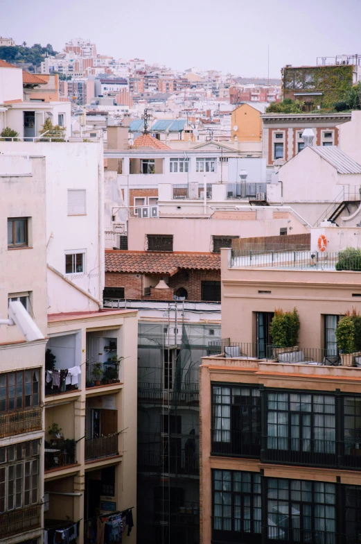 a view of a city from the top of a building, a picture, inspired by Tomàs Barceló, trending on unsplash, modernism, some houses in the background, roof with vegetation, low - angle shot from behind, square