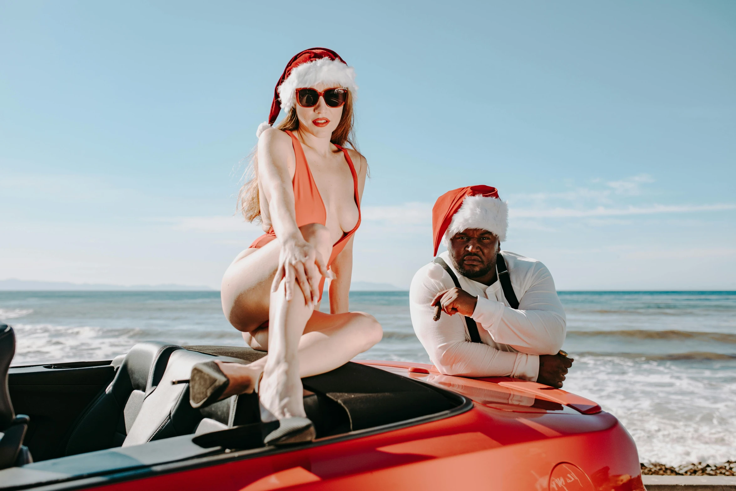 a woman sitting on top of a red car next to a man in a santa hat, pexels contest winner, renaissance, wearing a white bikini, 2 chainz, oceanside, lachlan bailey