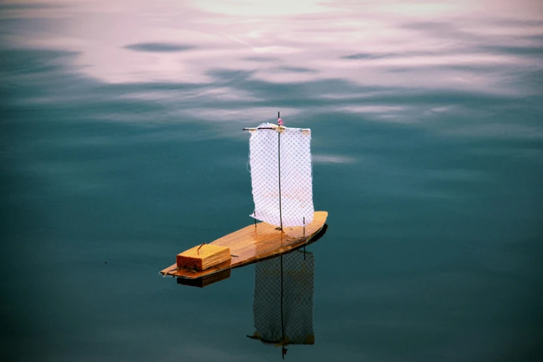 a small boat floating on top of a body of water, inspired by Quint Buchholz, unsplash contest winner, trireme, mini model, ignant, photo taken in 2 0 2 0