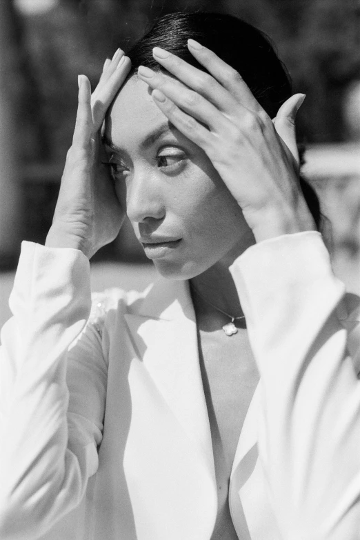 a black and white photo of a woman with her hands on her head, a black and white photo, by Maurycy Gottlieb, wearing white suit, kiko mizuhara, ashteroth, shot at golden hour