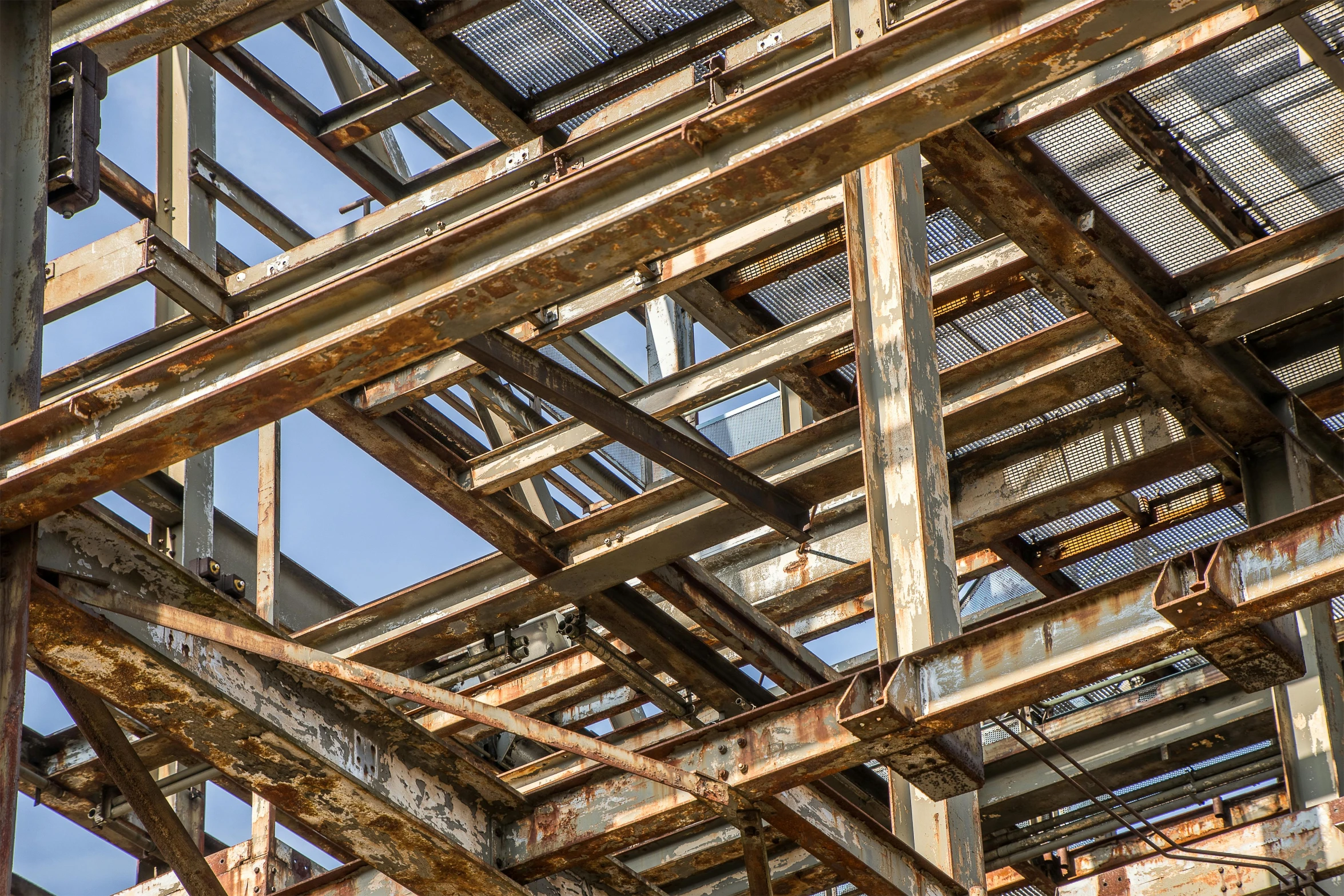 a close up of a metal structure with a blue sky in the background, unsplash, renaissance, hashima island, portrait image, ((rust)), beams