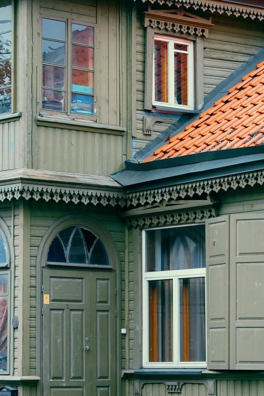 a red fire hydrant sitting in front of a green house, inspired by Julius Edvard Marak, art nouveau, wooden trim, orange roof, grey, kalevala