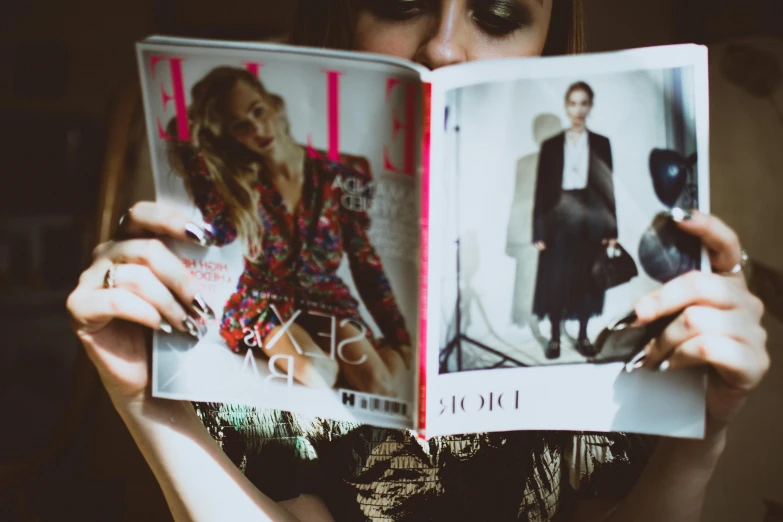 a woman holding a magazine in front of her face, trending on pexels, dressed in expensive clothes, elle magazine, fully body photo, glossy photo