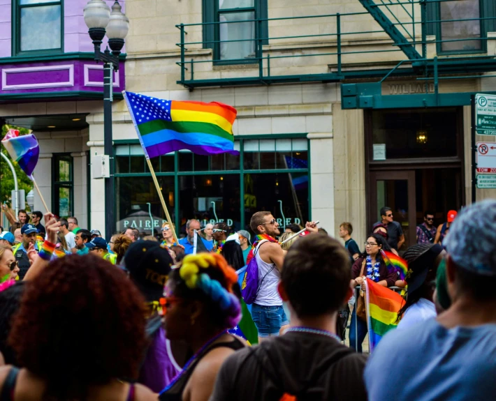 a large group of people walking down a street, by Meredith Dillman, pexels, lgbt flag, chicago, a person standing in front of a, well defined