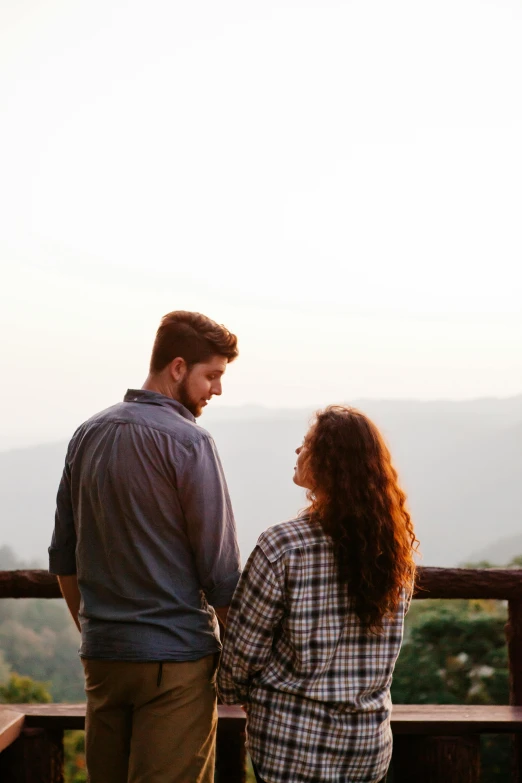 a man and a woman standing next to each other, pexels contest winner, overlooking, half turned around, hills, handsome