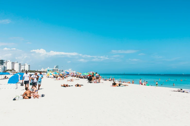 a beach filled with lots of people and umbrellas, miami beach, profile image, clear blue skies, 🚿🗝📝