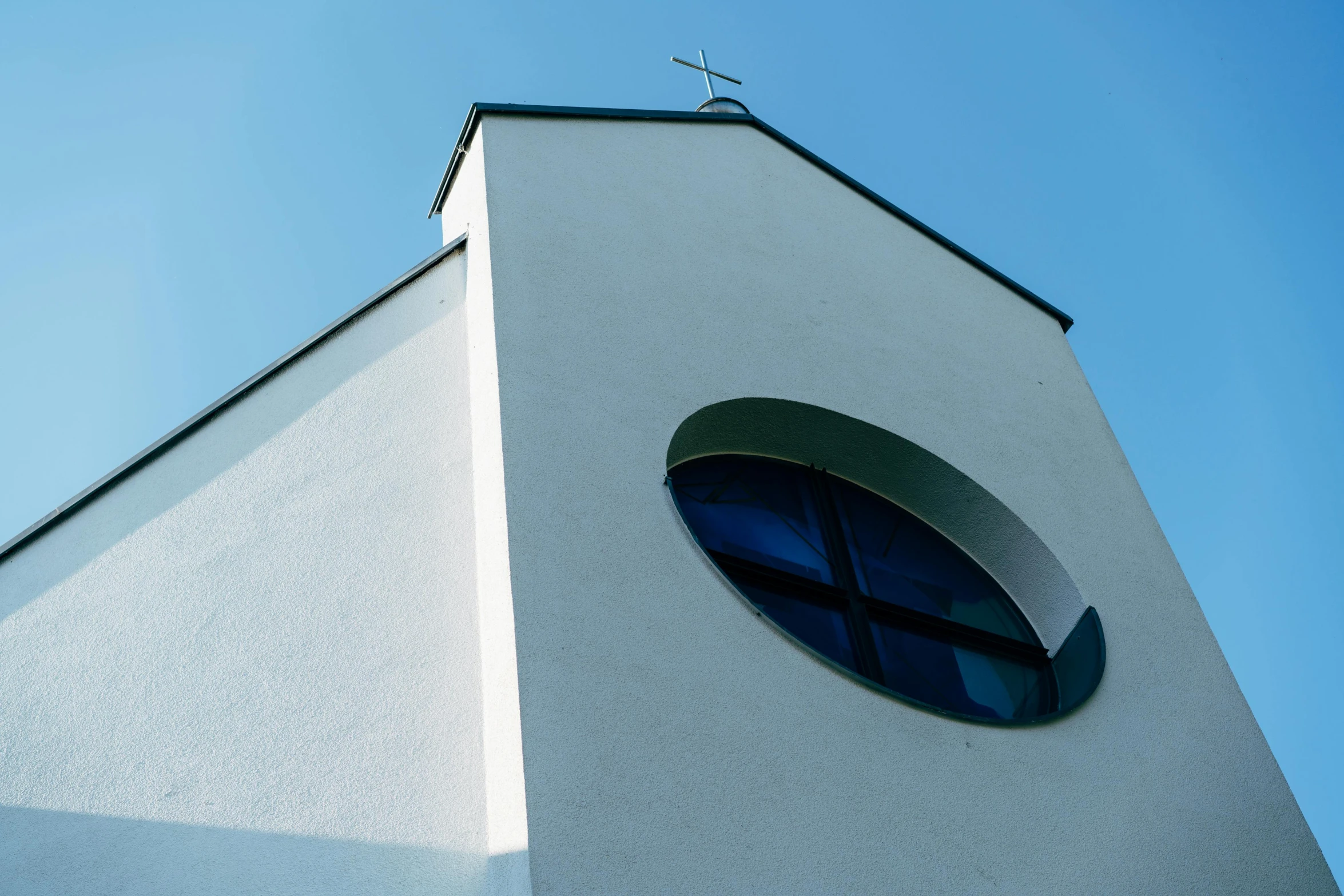 a clock tower with a cross on top of it, inspired by Bauhaus, unsplash, bauhaus, rounded roof, white and blue, church window, white wall complex