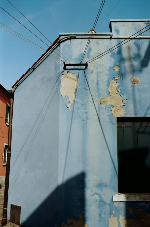 a red fire hydrant sitting in front of a blue building, inspired by Lucio Fontana, postminimalism, exposed wires, 1996), light-blue, photographed from the back