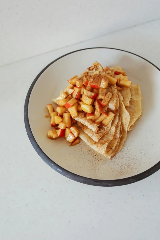 a white plate topped with pancakes and fruit, apples, folded, thumbnail, bowl