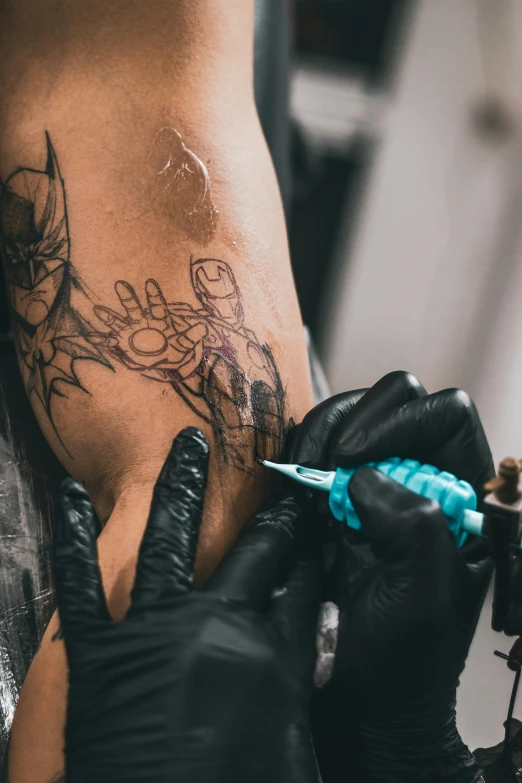 a man getting a tattoo on his leg, trending on pexels, process art, superhero, down left arm and back, sharpie, venom