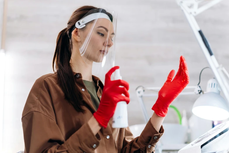 a woman in a brown shirt and red gloves, pexels contest winner, clean medical environment, profile image, sprays, plastic and fabric