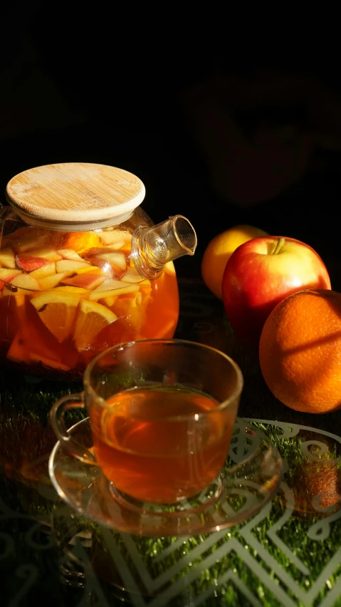 a cup of tea sitting on top of a glass table, a still life, inspired by Wlodzimierz Tetmajer, pexels, apple orange, hay, 8 l, pot