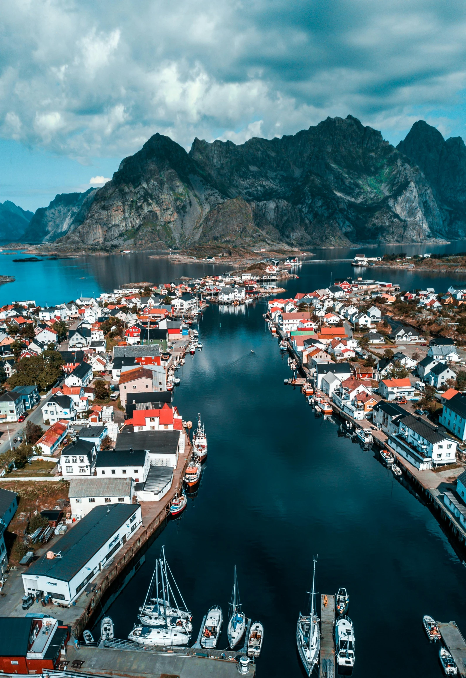 a harbor filled with lots of boats under a cloudy sky, by Sven Nordqvist, pexels contest winner, modernism, “ aerial view of a mountain, swedish houses, cinematic 8k hdr, white buildings with red roofs