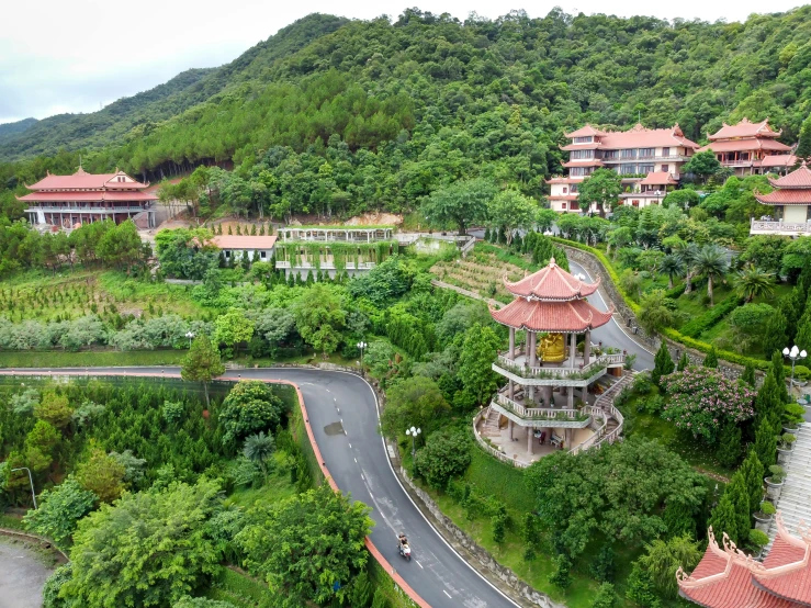 a bird's eye view of a resort in the mountains, ao dai, chinese temple, hilly road, exterior botanical garden