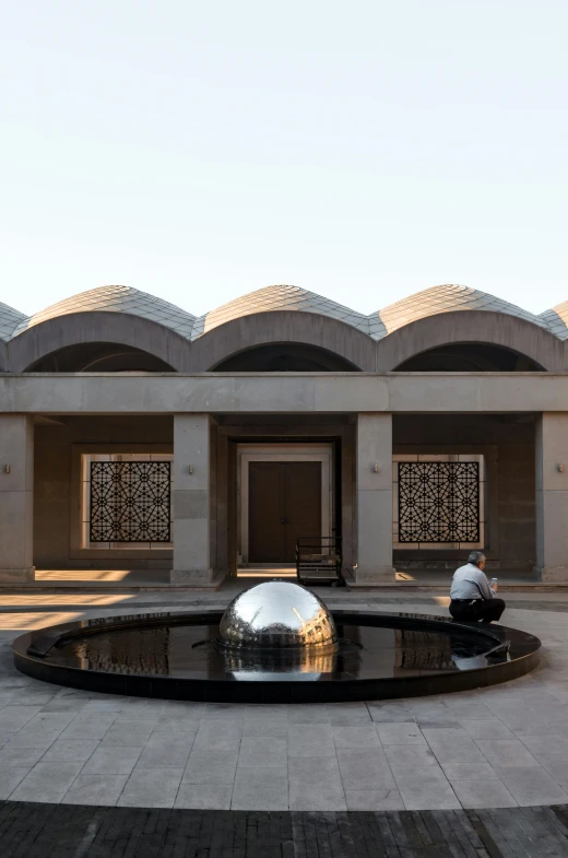 a building with a fountain in front of it, a marble sculpture, inspired by Ahmed Yacoubi, vault, spheres, exterior shot, steel archways