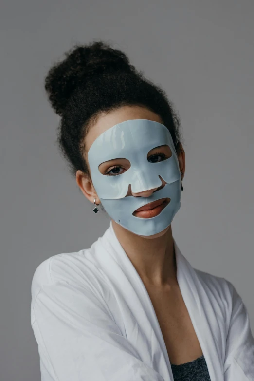 a woman with a blue mask on her face, product shot, grey, frontshot, diverse