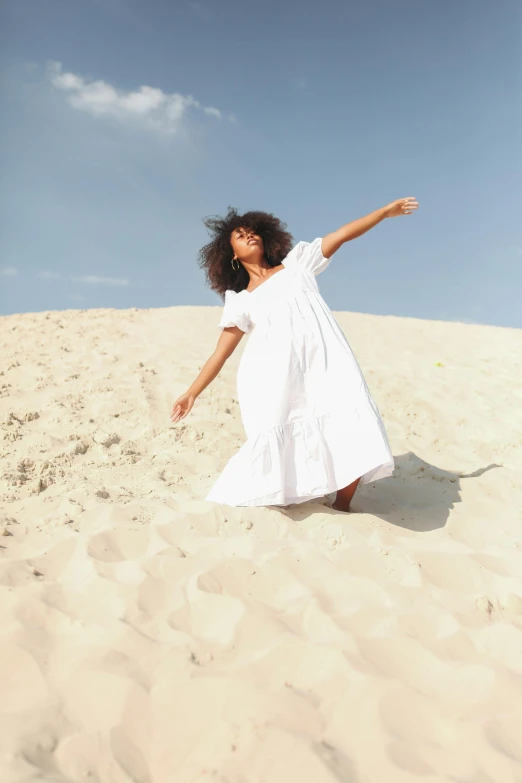 a woman in a white dress standing in the sand, pexels contest winner, arabesque, waving robe movement, sza, essence, on dune