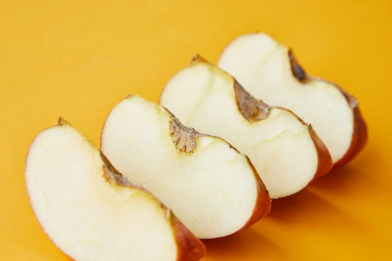 a close up of a sliced apple on a yellow surface, trending on pexels, “ iron bark, detailed product image, orange fluffy spines, 6 pack