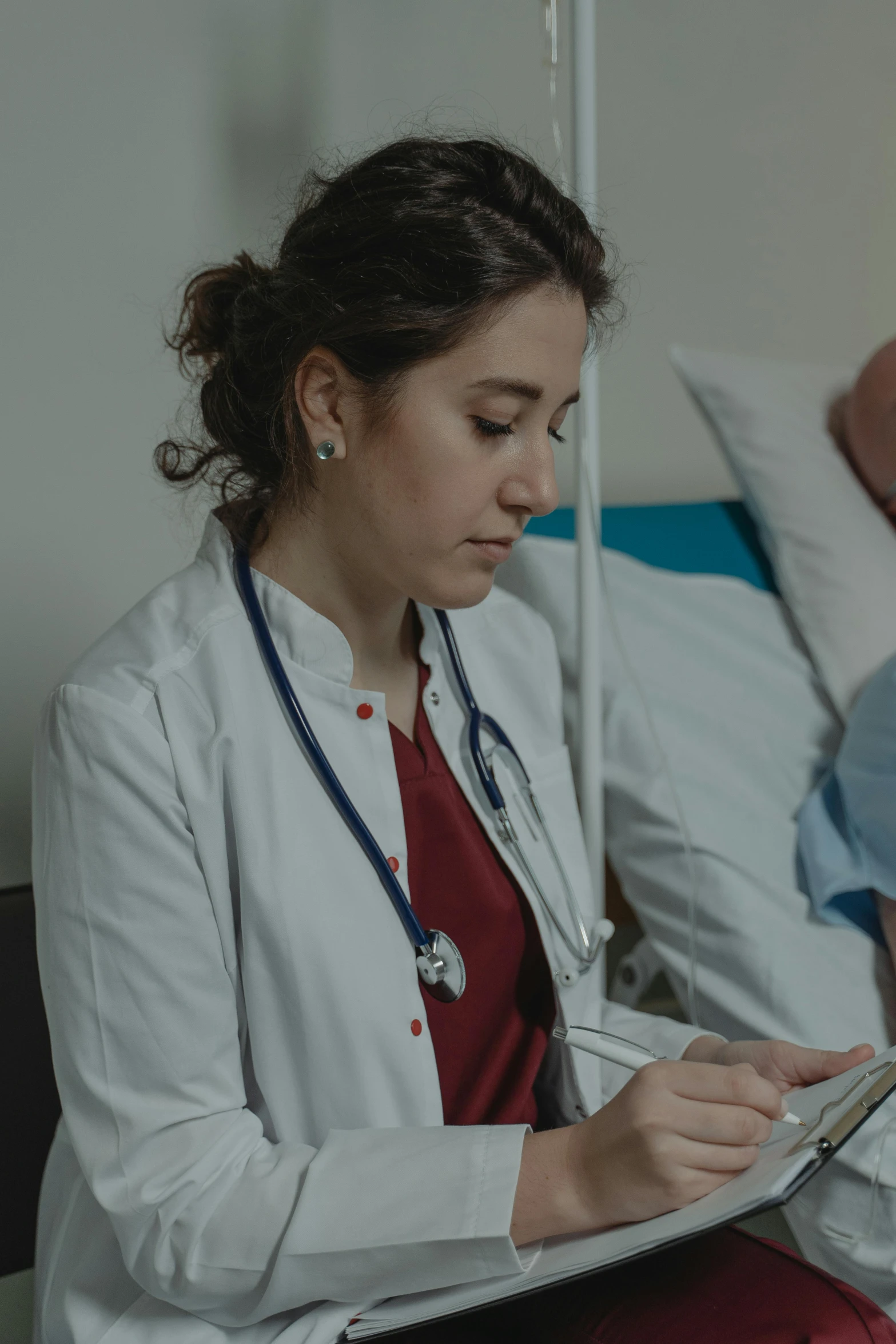 a woman with a stethoscope sitting next to a man in a hospital bed, inspect in inventory image, zoomed in, medical book, lightweight