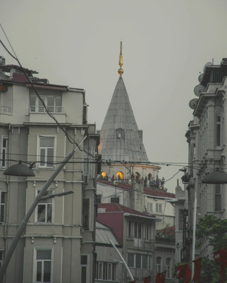 a clock that is on the side of a building, black domes and spires, under a gray foggy sky, turkish and russian, view from across the street