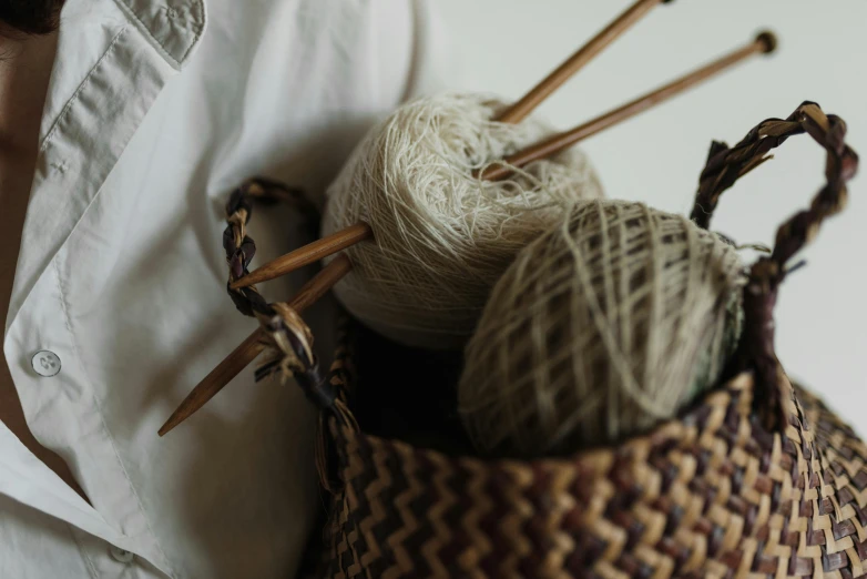 a woman holding a basket of yarn and knitting needles, trending on pexels, arts and crafts movement, brown, linen, textile, inspiration