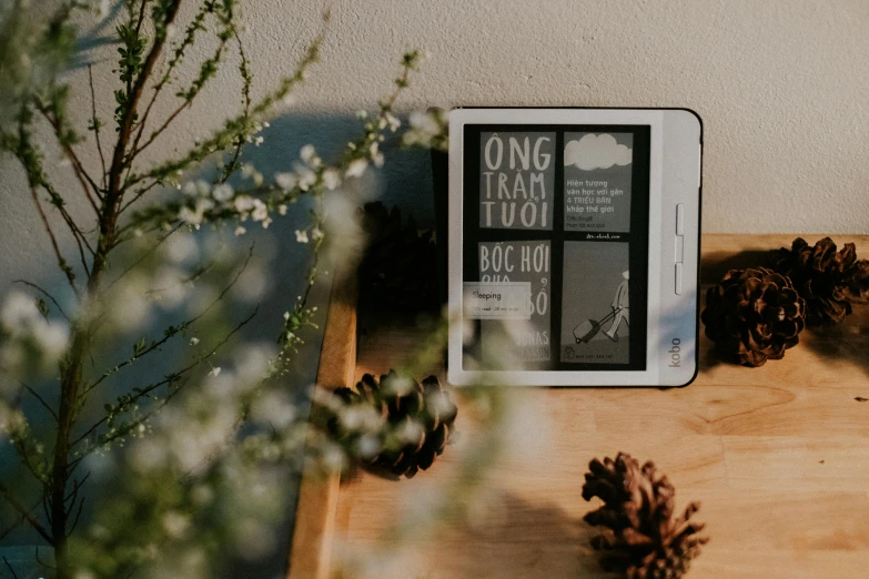 a tablet computer sitting on top of a wooden table, a black and white photo, by Robbie Trevino, unsplash, happening, books and flowers, punpun onodera, decoration, background image