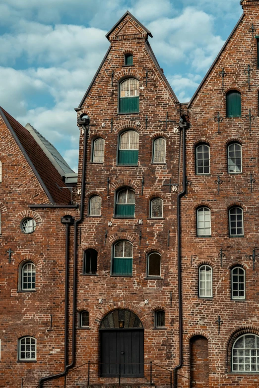 a large brick building with a clock on top of it, inspired by Matthias Jung, pexels contest winner, warehouses, asymmetrical spires, lower saxony, panorama