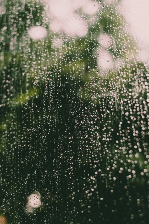 a close up of a window with raindrops on it, inspired by Elsa Bleda, unsplash contest winner, green rain, water is made of stardust, rain sensor, promo image