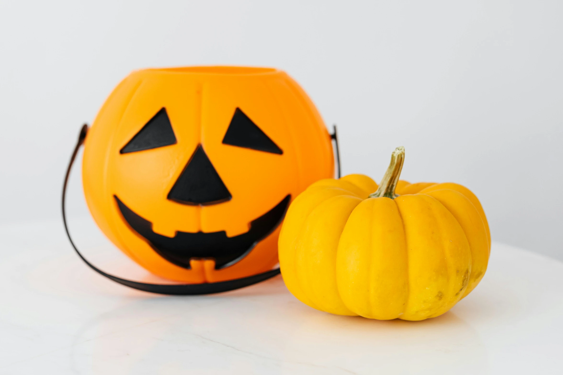 two pumpkins sitting next to each other on a table, pexels, holding a lantern, with a white background, candy treatments, no - text no - logo