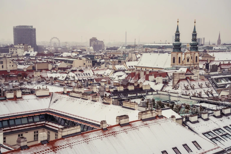 a view of a snowy city from the top of a building, by Adam Marczyński, pexels contest winner, rococo, old color photograph, roofs, 2000s photo, with snow on its peak