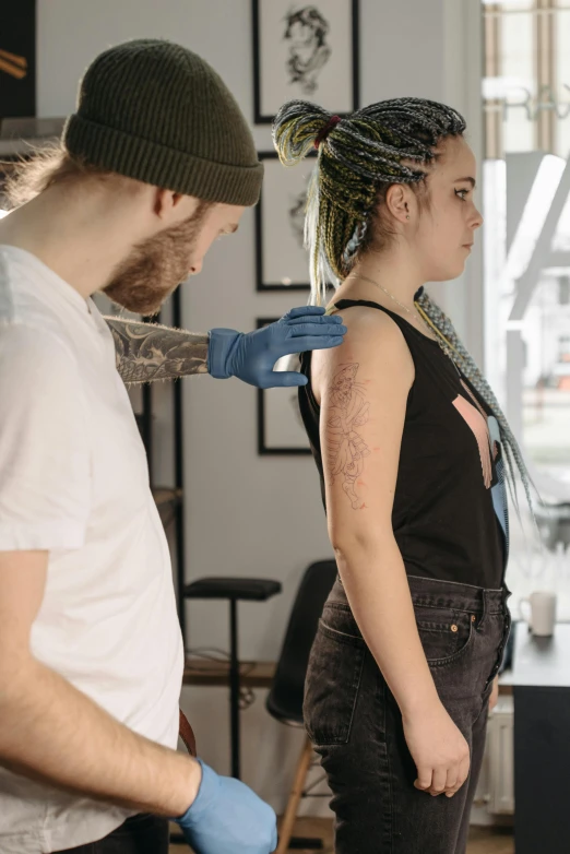 a man getting a tattoo on a woman's arm, a tattoo, by Adam Marczyński, trending on pexels, hyperrealism, hand - tinted, thumbnail, full body 8k, teenage girl