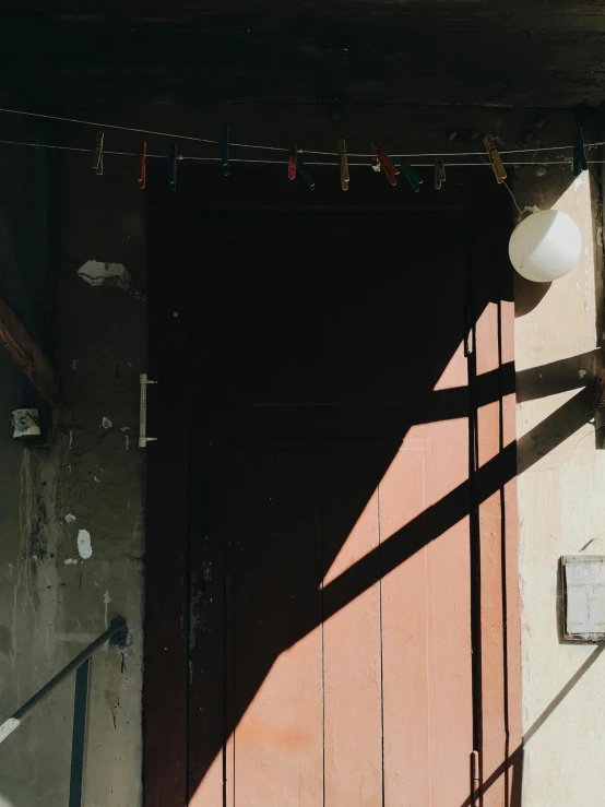 a cat sitting on a chair in front of a door, by Elsa Bleda, unsplash, light and space, wires hanging above street, hanging lanterns, background image, in front of a garage