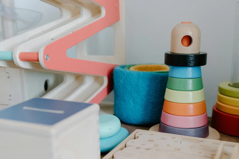 a pile of wooden toys sitting on top of a table, by Emma Andijewska, trending on pexels, pink and teal and orange, with a bunk bed, close-up product photo, games