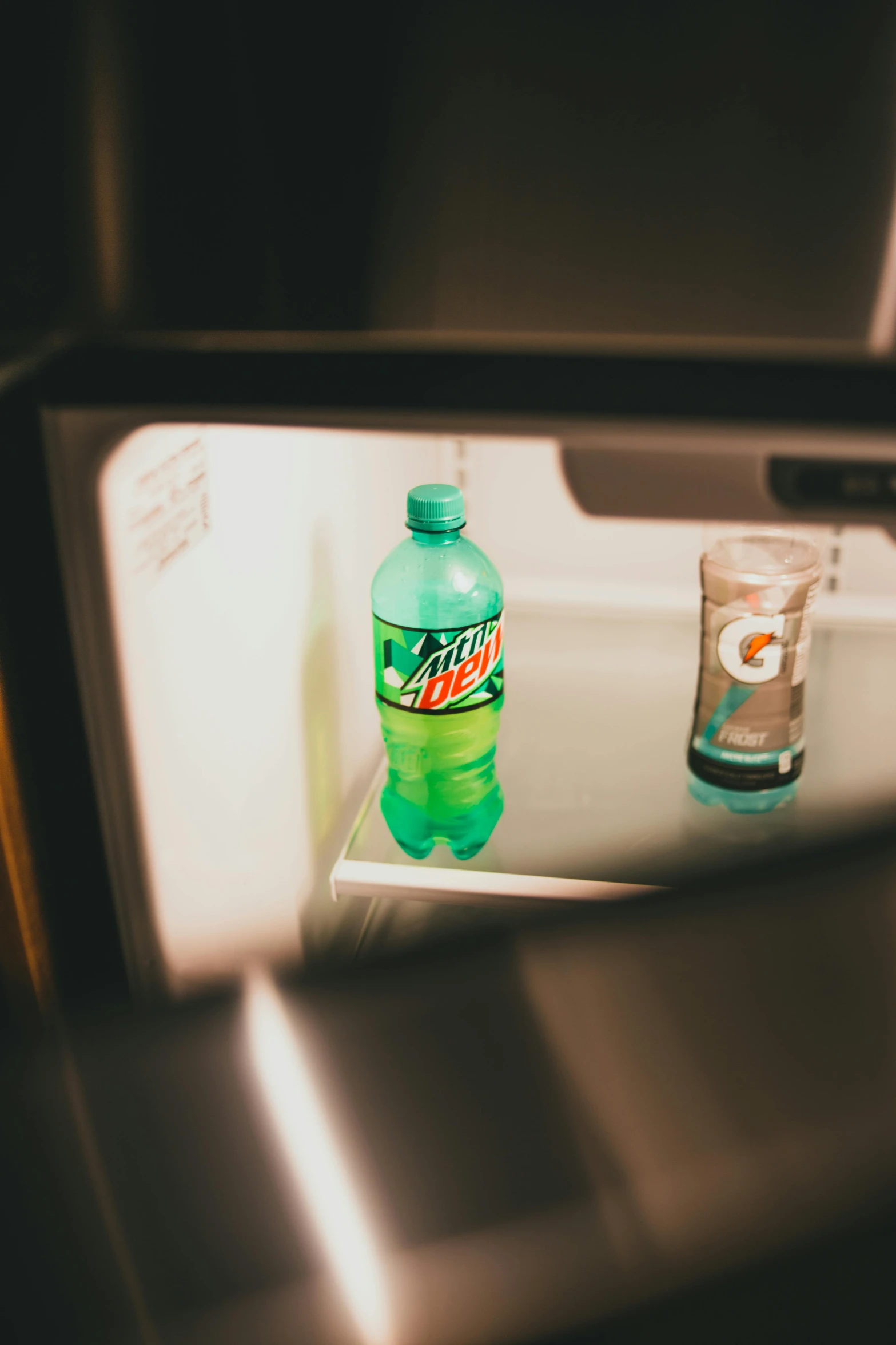 a bottle of soda sitting inside of a refrigerator, inspired by Elsa Bleda, unsplash, hotel room, green light, snacks, petra collins