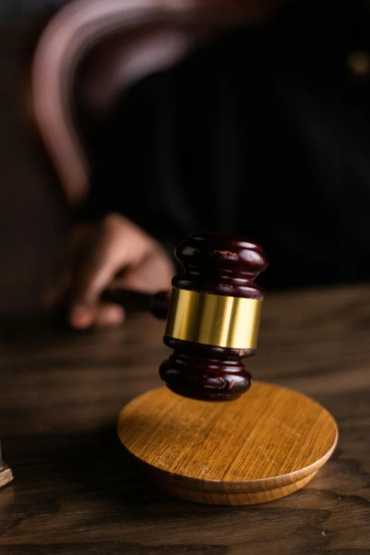 a wooden gavel sitting on top of a wooden table, sitting on a table, pictured from the shoulders up, hovering indecision, no - text no - logo