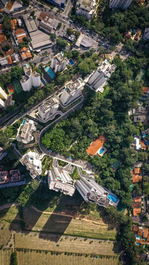 an aerial view of a city with lots of buildings, by Sam Black, pexels contest winner, photorealism, lush forests, alvaro siza, singapore, staggered terraces