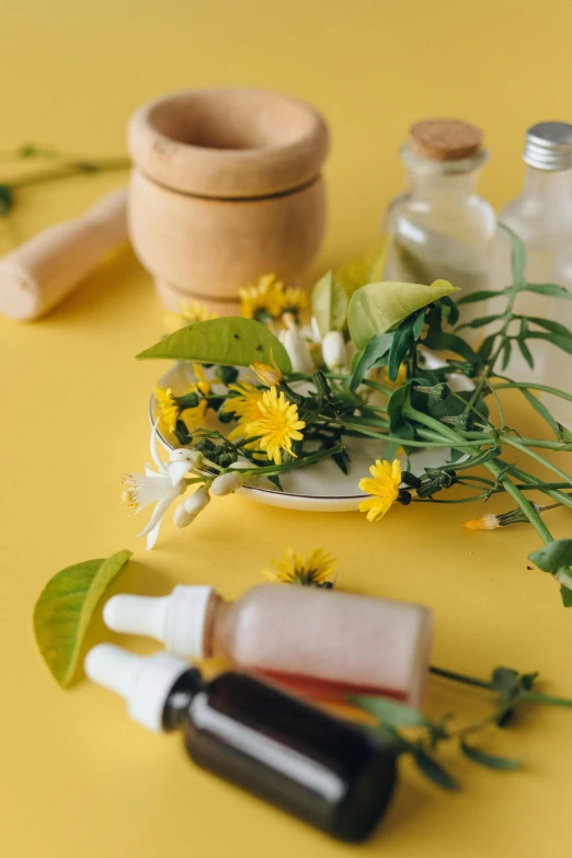 a couple of bottles sitting on top of a table, yellow flowers, skincare, herbs and flowers, thumbnail