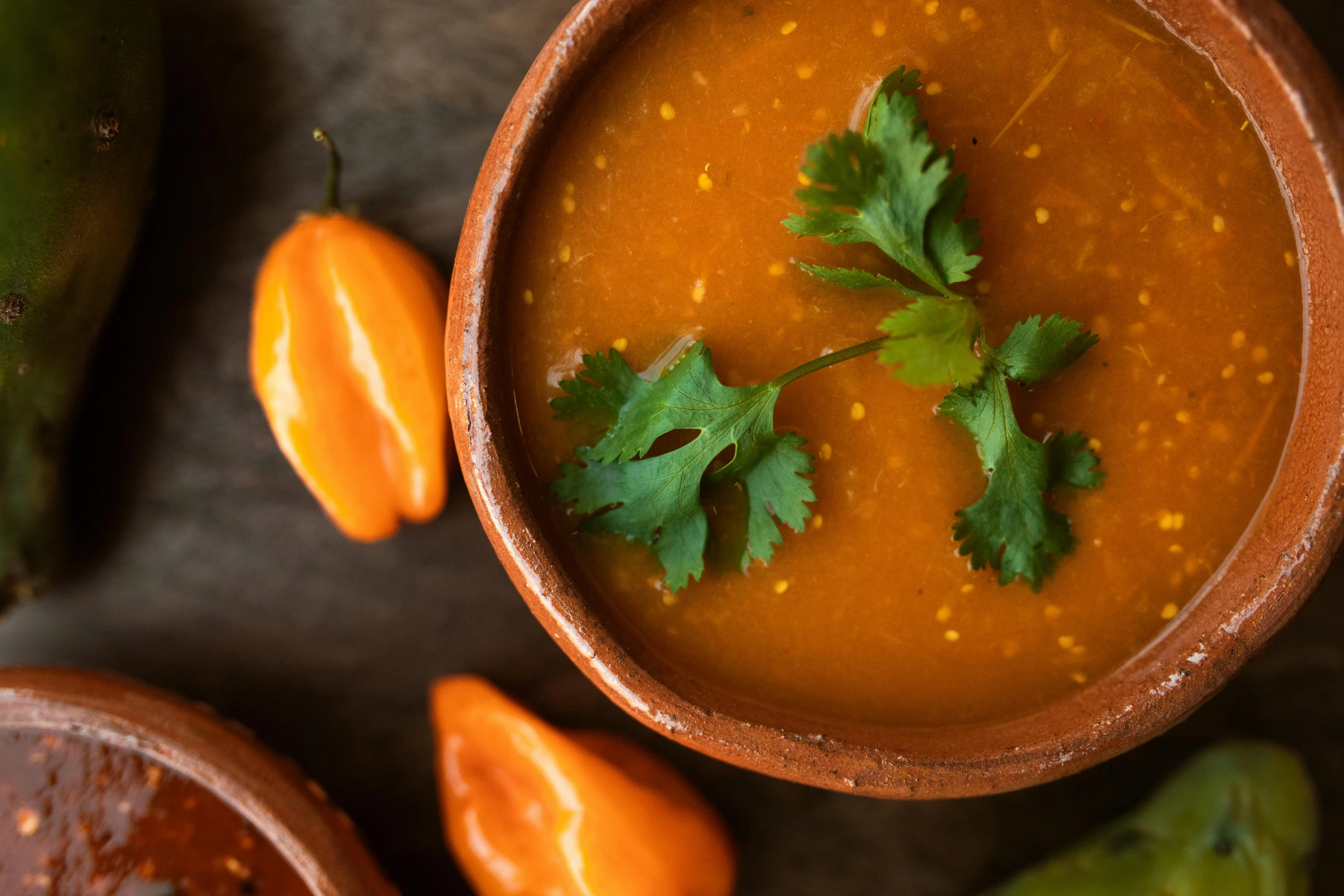 a bowl of soup sitting on top of a table, bhut jolokia, terracotta, thumbnail, detail shot