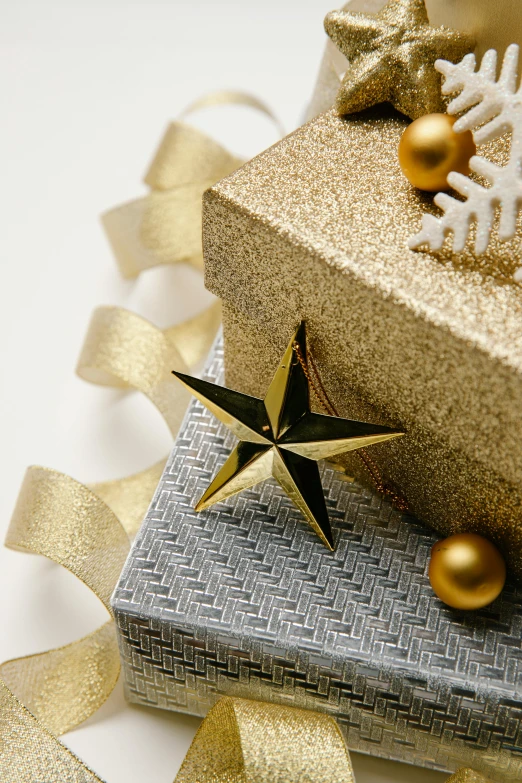 a close up of a gift box on a table, a photo, by David Garner, shutterstock contest winner, gold and silver shapes, star, ornament, high angle close up shot