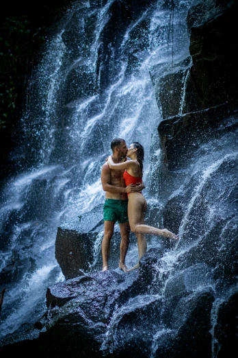 a couple kissing in front of a waterfall, an album cover, inspired by Steve McCurry, bali, body shot, modelling, f / 2 0