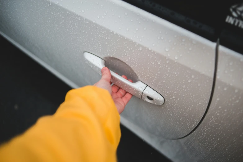 a person is opening the door of a car, pexels contest winner, detailed moisture, silicone cover, metal handles, hidden message