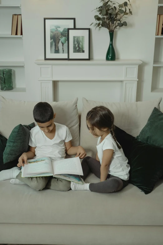 a couple of kids sitting on top of a couch, reading, riyahd cassiem, environment, english