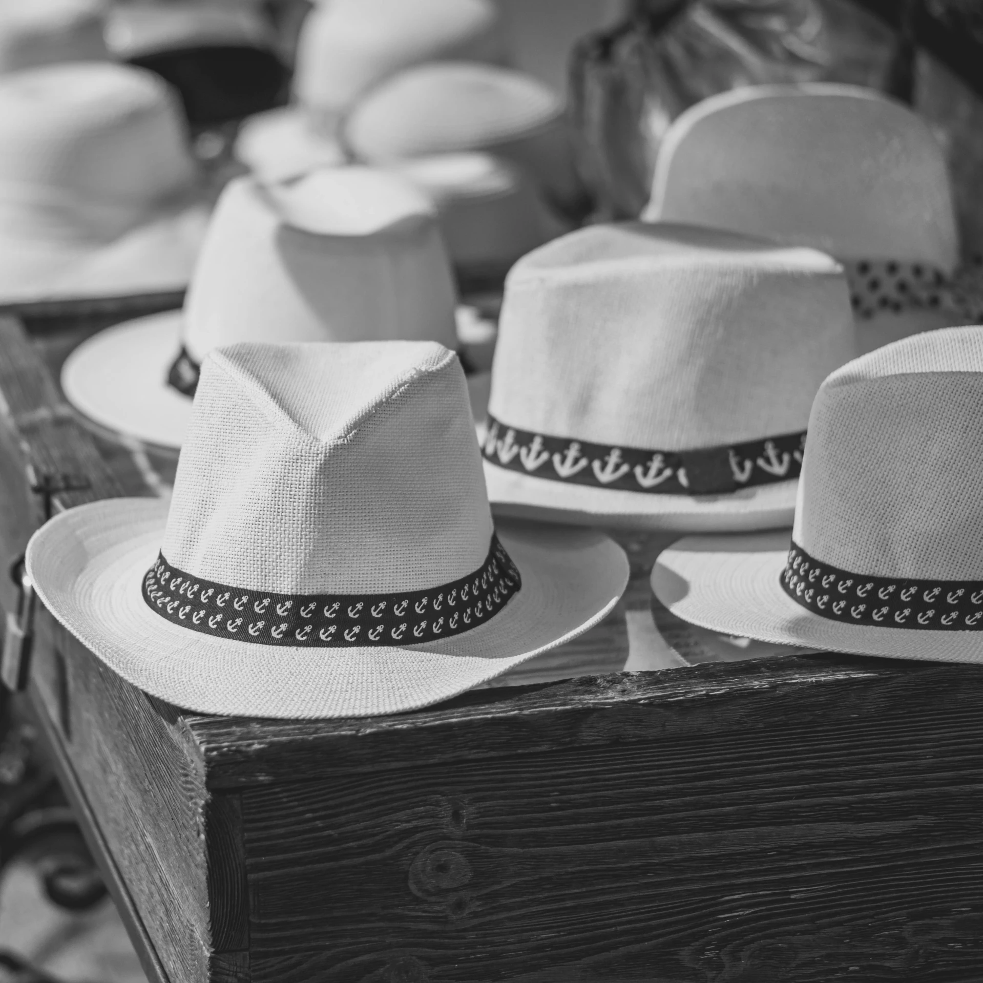 a bunch of hats sitting on top of a wooden box, a black and white photo, pexels, white cowboy hat, retro stylised, white color, festival