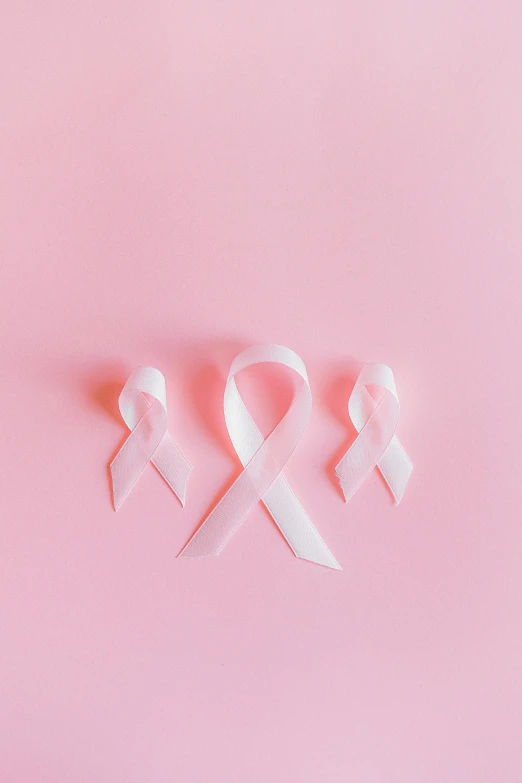 a pink ribbon on a pink background, by Carey Morris, pexels contest winner, happening, with a white complexion, 3 - piece, made of lab tissue, white background