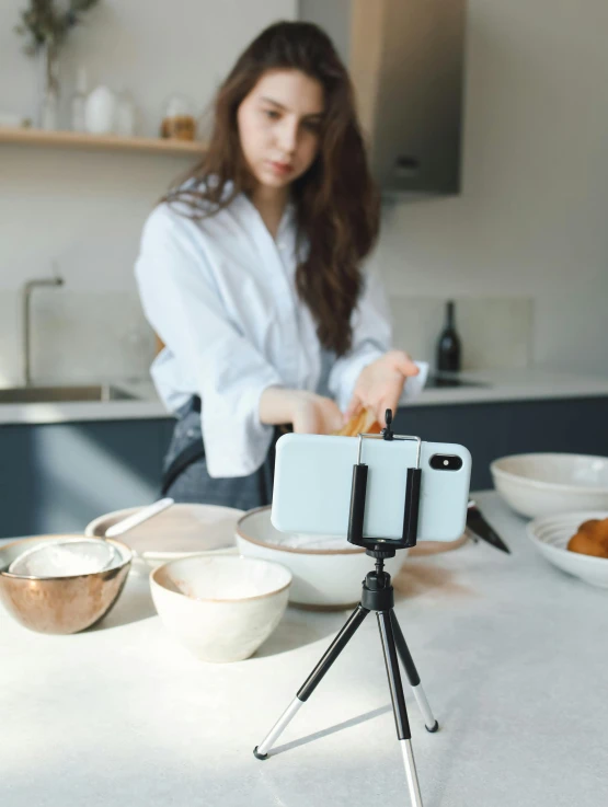 a woman taking a picture of food on a tripod, a picture, unsplash, video art, low quality photo, all marble, portrait mode photo, modern”