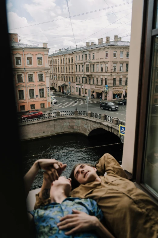 a man laying on top of a bed next to a window, by Nina Hamnett, pexels contest winner, saint petersburg, holding each other, canal, low quality photo