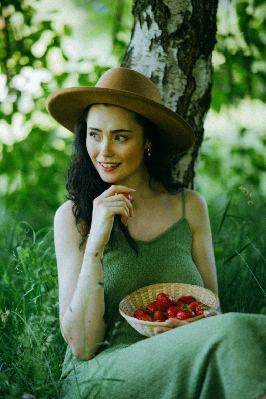 a woman sitting under a tree with a bowl of strawberries, pexels contest winner, renaissance, green hat, krysten ritter, anna nikonova aka newmilky, woman with braided brown hair