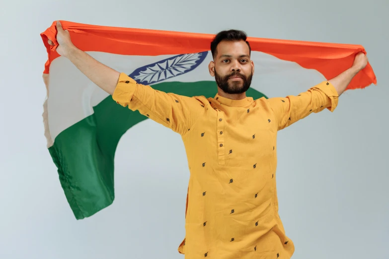 a man in a yellow shirt holding an indian flag, pexels contest winner, doing an elegant pose, instagram post, 2 0 7 7